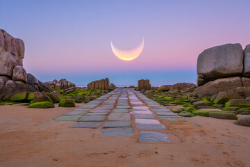 Magical beach scenery with a path of stone tiles leading to a celestial crescent moon landscape fantasy travel dreamlike shore