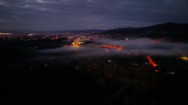 evening mist shrouds distant rolling hills, soft illumination dances across suburban rooftops