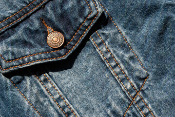 Detailed view of blue jean jacket pocket texture.