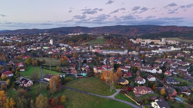 sunset aerial overview of settlement, twilight city landscape highlighting rooftops and roads