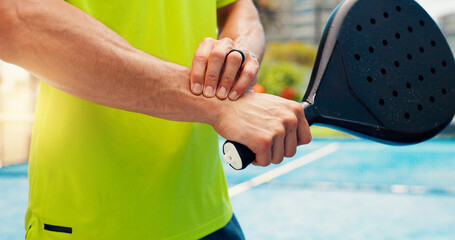 Naklejka premium Man, hands and wrist pain with padel for sport injury, muscle tension or accident for match or game. Closeup, male person or sore arm with bat for discomfort, overworked or emergency on outdoor court