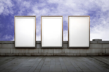 Empty tall rectangular signage display attached to a simple stone wall, with expansive clear blue sky dominating the background, offering a versatile design template for businesses