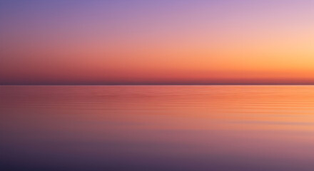 Calm water reflects a gradient sunset sky transitioning from purple to orange