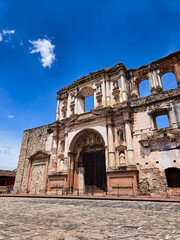 Ancient Architectural Echoes: Standing tall against a vast blue sky, weathered stone walls of an ancient architectural marvel stand.