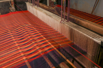 Saree weaving on a traditional wooden handloom in tamilnadu