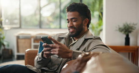 Home, cellphone and man on sofa, smile and social media with communication. Smartphone, relax and...