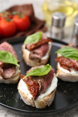 Bruschettas with roast beef served on table, closeup