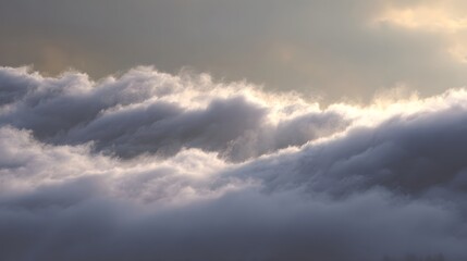 Obraz premium Rolling layers of dense fog or clouds are illuminated by soft warm light at dawn creating a serene ethereal atmosphere