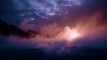 Obraz premium Mysterious dawn breaks over choppy ocean waters with dense fog obscuring a dark silhouette and vibrant cloud filtered sunlight
