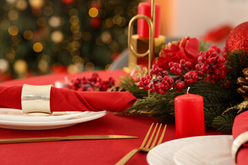 Stylish Christmas table setting with plates, festive decor and candles indoors, closeup