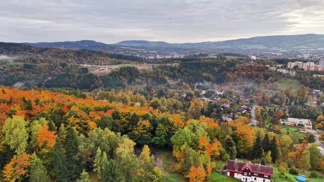 drone captures layout of hillside community, scenic suburban zone with orchard and town views