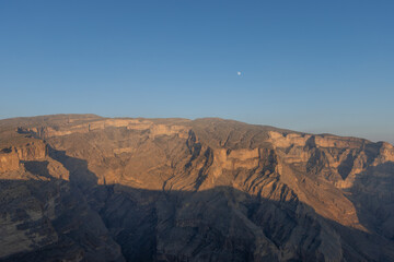 Grand Canyon of Oman during sunset with moon above the mountains, Jebel Shams is the highest mountain of Oman