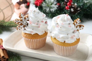 Tasty cupcakes with Christmas decor and cinnamon on table, closeup
