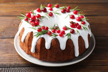Tasty Christmas cake with cranberries on wooden table, closeup