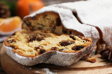 Traditional Christmas Stollen with icing sugar on table, closeup