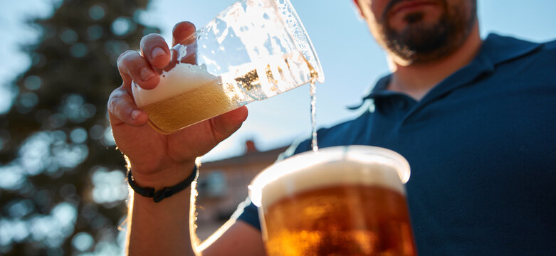 People holding beer cups and enjoying summertime outdoors.