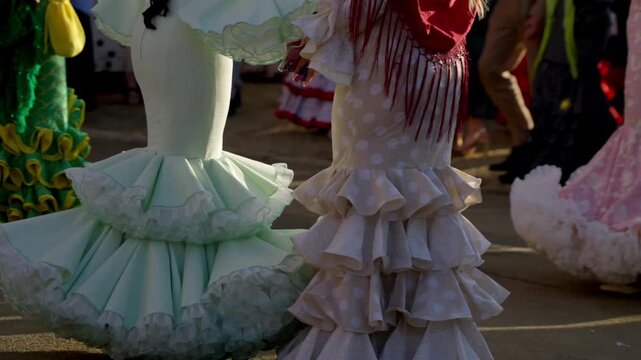 Soft ruffles of a white flamenca dress dance in the afternoon sun at the Feria