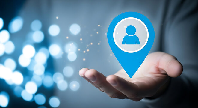 Person holding a blue location pin with a human icon in their hand, representing user location or employee location tracking. - Powered by Adobe
