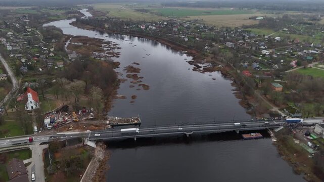 Salacgriva, Latvia - November 12, 2025: Aerial view of a bridge over a river, showcasing construction progress with camera zooming out for context
