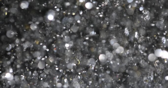 Spellbound vortex of shimmering silver confetti floating in air at party. Celebrating New Year holiday with glitter decor and  festive mood