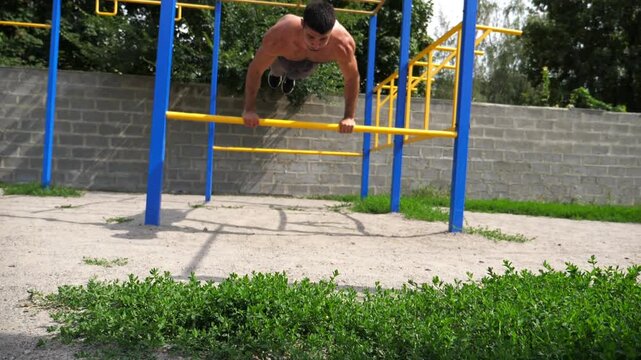 Sportsman performing dynamic workout routine on parallel bars, showcasing strength and agility through a series of fluid movements in an outdoor training environment with vibrant greenery