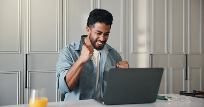 Excited, man or celebration with laptop in kitchen for trading success, financial win and remote work. Freelancer, trader or victory fist with tech in home for price target notification or investment - Powered by Adobe