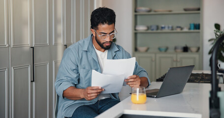 Reading, paperwork and man with laptop, home and writer with royalty statement or financial analysis. Creative, author and person with documents for self employment, remote work and tax preparation