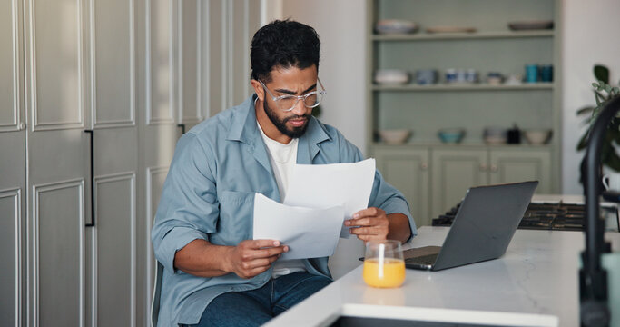 Reading, paperwork and man with laptop, home and writer with royalty statement or financial analysis. Creative, author and person with documents for self employment, remote work and tax preparation