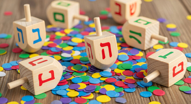 wooden dreidels spinning top for hanukkah jewish holiday over glitter gold background - Powered by Adobe