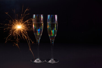 Sparkling Celebration. Two champagne glasses with bright sparklers against a dark background