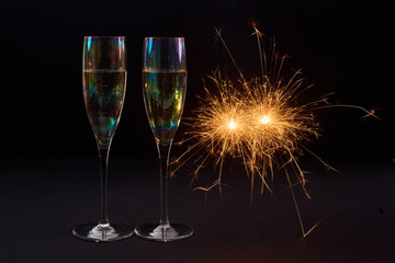 Sparkling Celebration. Two champagne glasses with bright sparklers against a dark background