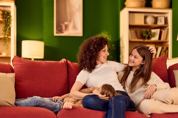 Obraz premium Happy Family Relaxing on Red Couch in Cozy Living Room Spending Quality Time Together