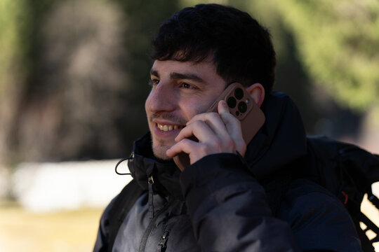 Young man enjoying phone call outdoors smiling