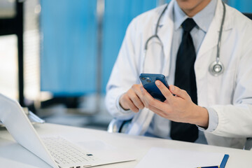 Doctor working with a tablet and smartphone search for medical information at the hospital office during the day.