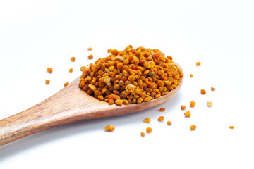 bee pollen grains in wooden spoon isolated on white background