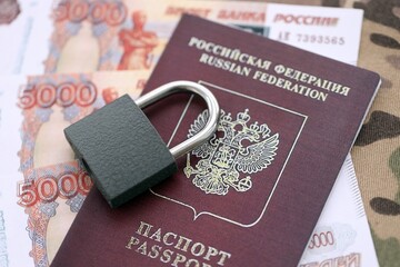 Russian rubles money bills and passport under ban of heavy lockpad close up. Concept of sanctions and restrictions to russian citizens
