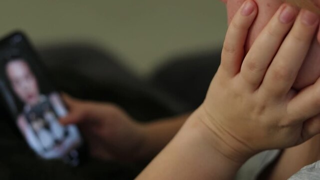 Close up of a young woman at home laying on a couch and scrolling social media, unfocused smartphone screen 