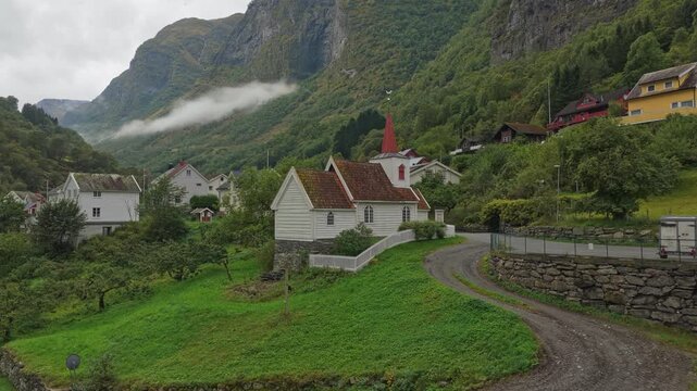 High-angle view of the tiny Undredal Stave Church surrounded by dramatic landscape, Norway