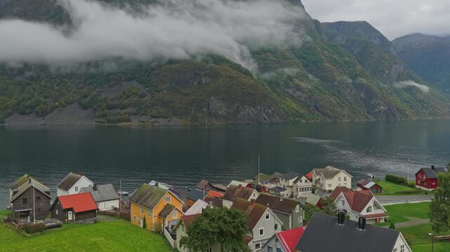 Drone view of the iconic fishing village Undredal set between towering fjord cliffs, Norway