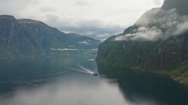 Aerial view of sightseeing vessel in fjord waters by Undredal, surrounded by cliffs