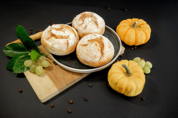 Pumpkins and freshly baked buns on black background