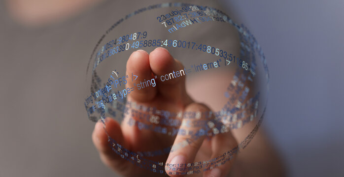 Close-up of a hand interacting with a digital globe displaying abstract code, symbolizing technology, connection, and data. Suitable