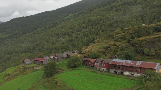 Aerial view of historic Otternes farm settlement by fjord under cloudy skies in Norway