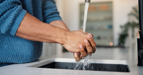 Person, water and washing hands with tap in kitchen for hygiene, disinfection or rinse in home. Self care, man or sink with faucet, health or safety for clean skin, bacteria or germ removal in house