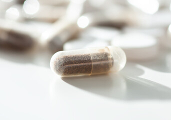 Close-up of multicolored supplements on pale background. Suggests vitality and self-care routine.
