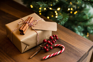Brown Christmas gift box with a blank tag on rustic wooden table.