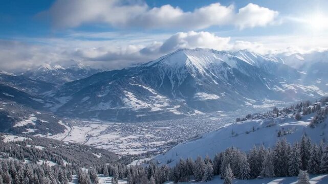 This video showcases a breathtaking panoramic view of a majestic winter mountain landscape. Towering snow-capped peaks dominate the horizon under a serene blue sky, dotted with soft, fluffy white clou