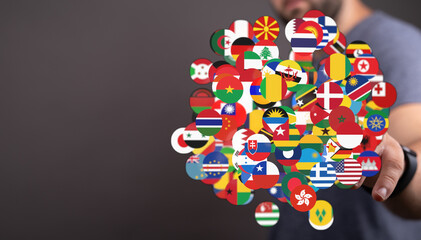 A man's hand holds a collection of country flags, symbolizing global cooperation and international connections. Suitable for concepts of globali