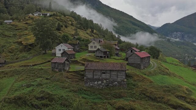 Traditional farm cluster Otternes seen from above on a misty fjord day, Norway