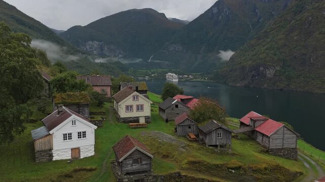 Foggy fjord landscape with Otternes heritage homes seen from drone in Norway